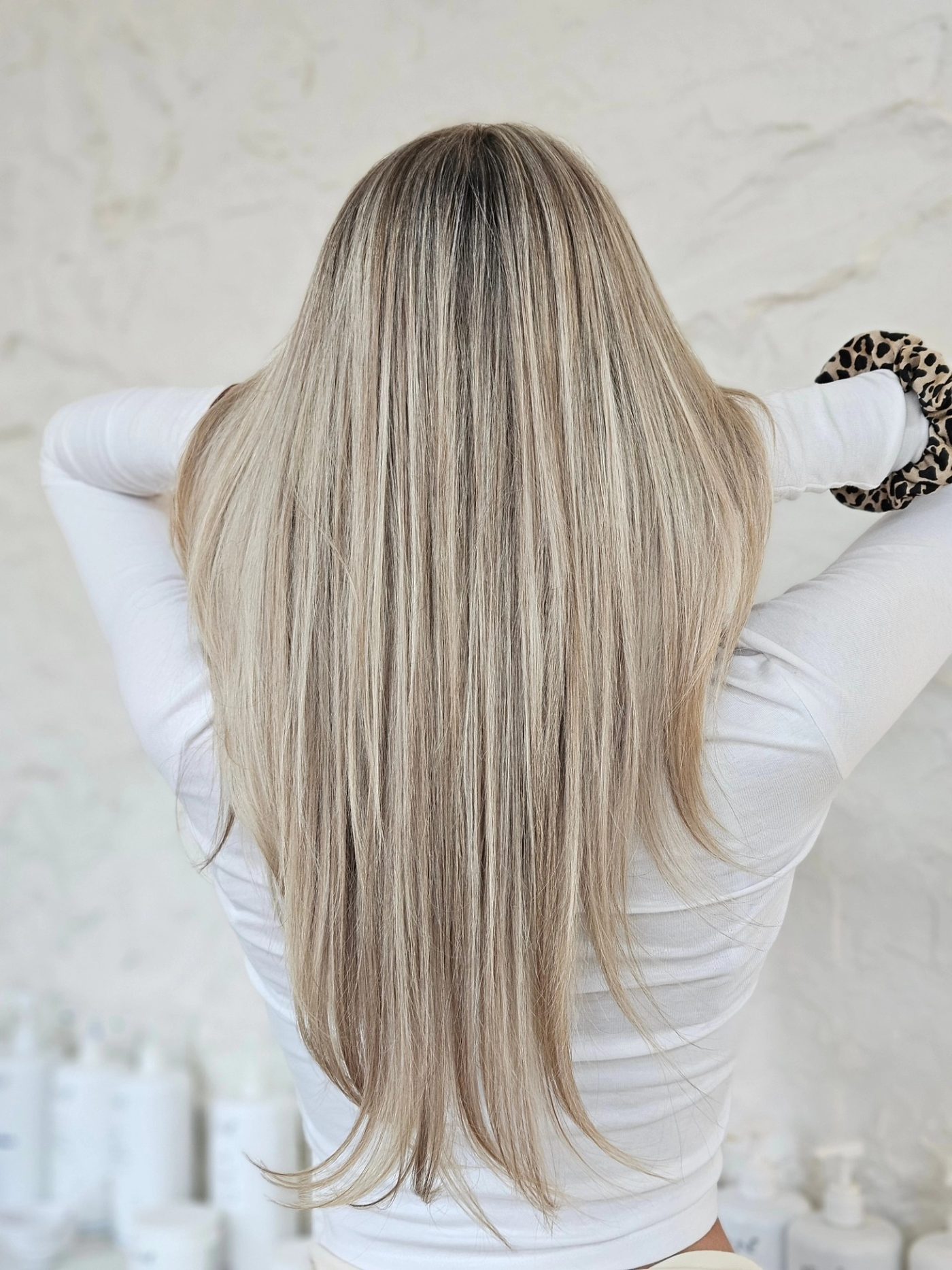 Lang blond haar met zachte highlights, van achteren gefotografeerd in de salon