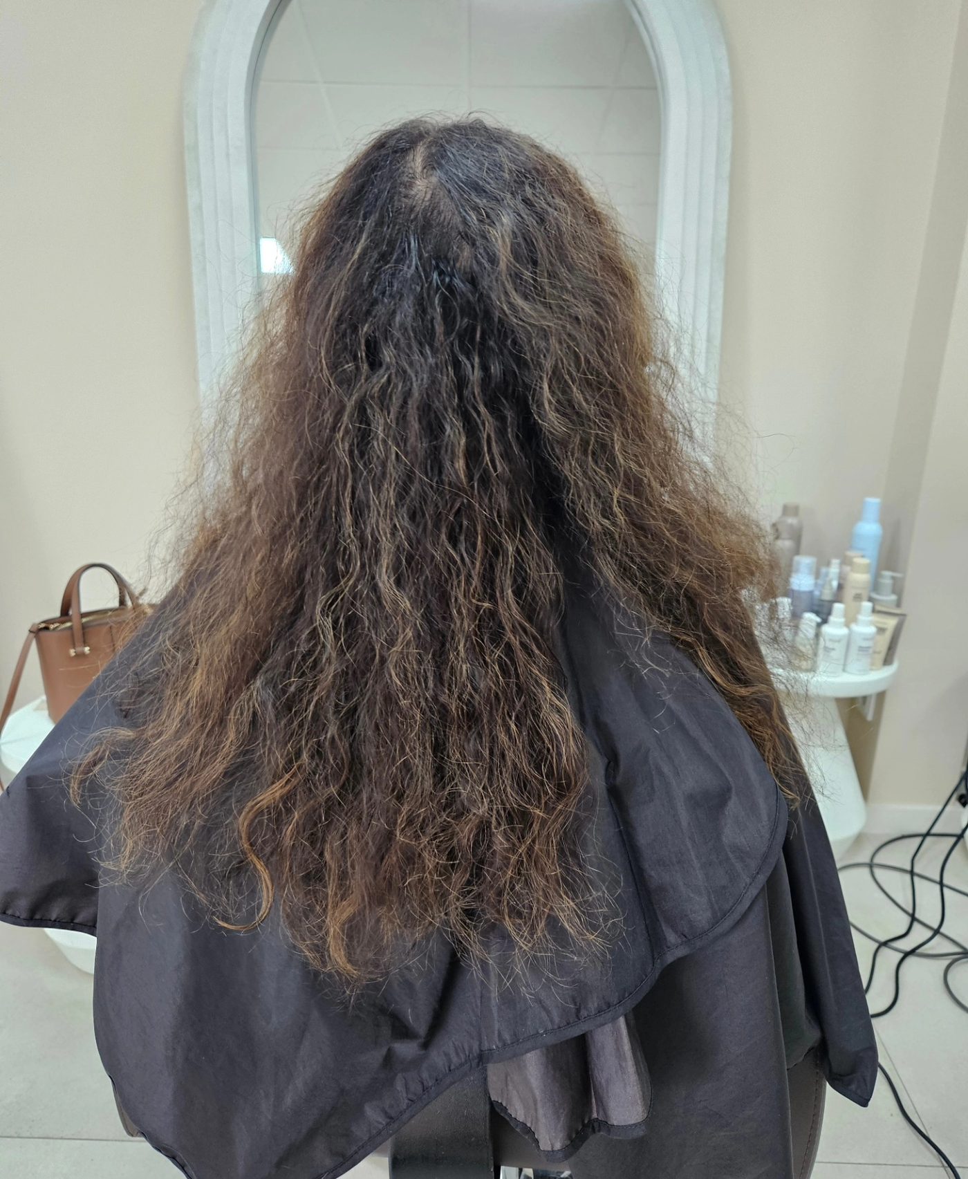 Voor: lang, pluizig donkerbruin haar met uitgegroeide karamel punten