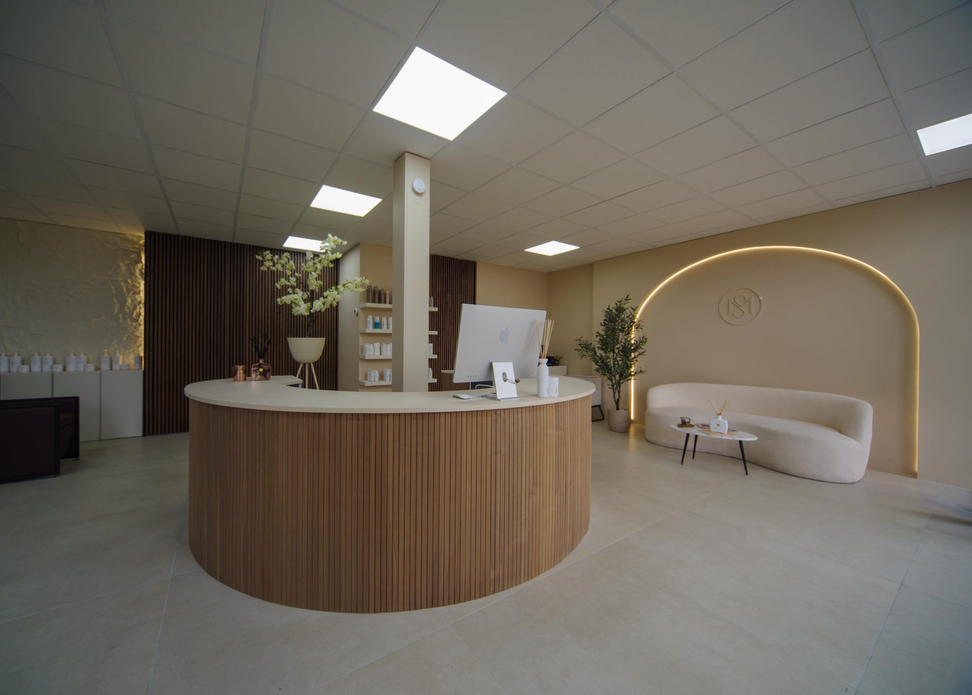 De ronde balie van eikenhout en de zithoek in de verlichte boog van Melana Studio