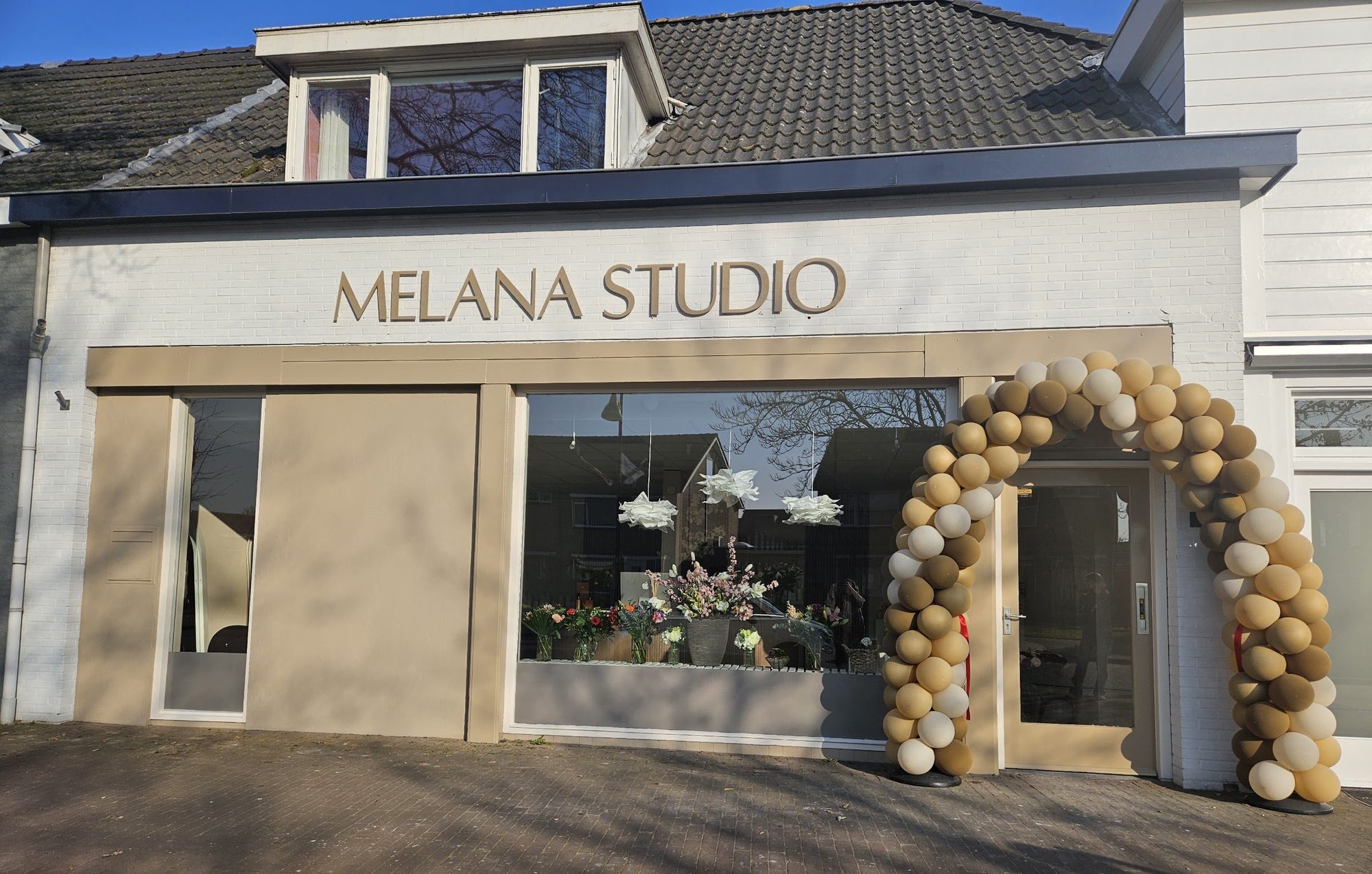 De gevel van Melana Studio met ballonboog op de openingsdag